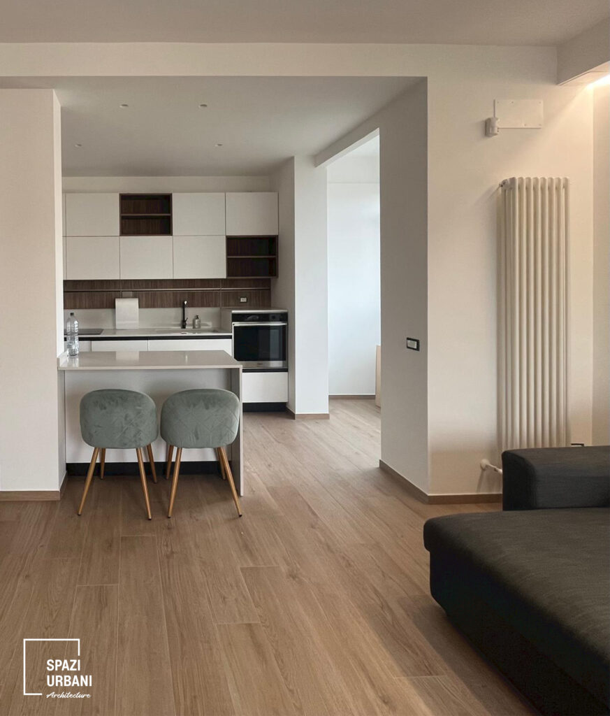 Ristrutturazione interna Casa F&F: zona giorno con pavimento effetto rovere e pareti color salvia